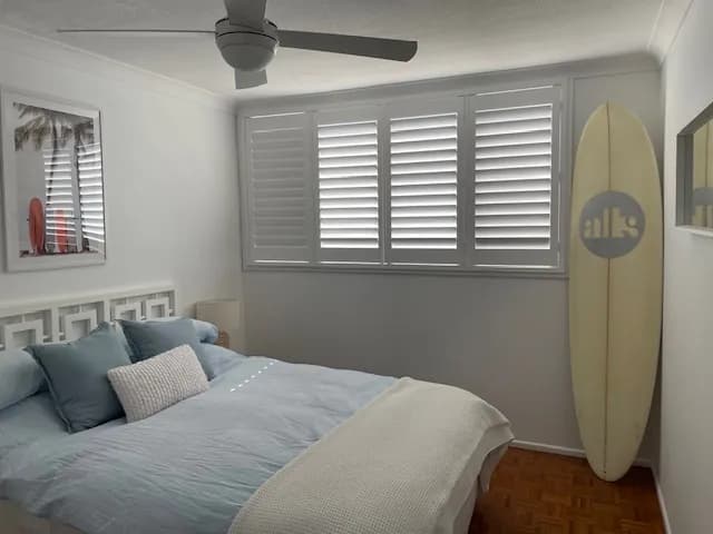 White plantation shutters on a bedroom window — one of our own jobs