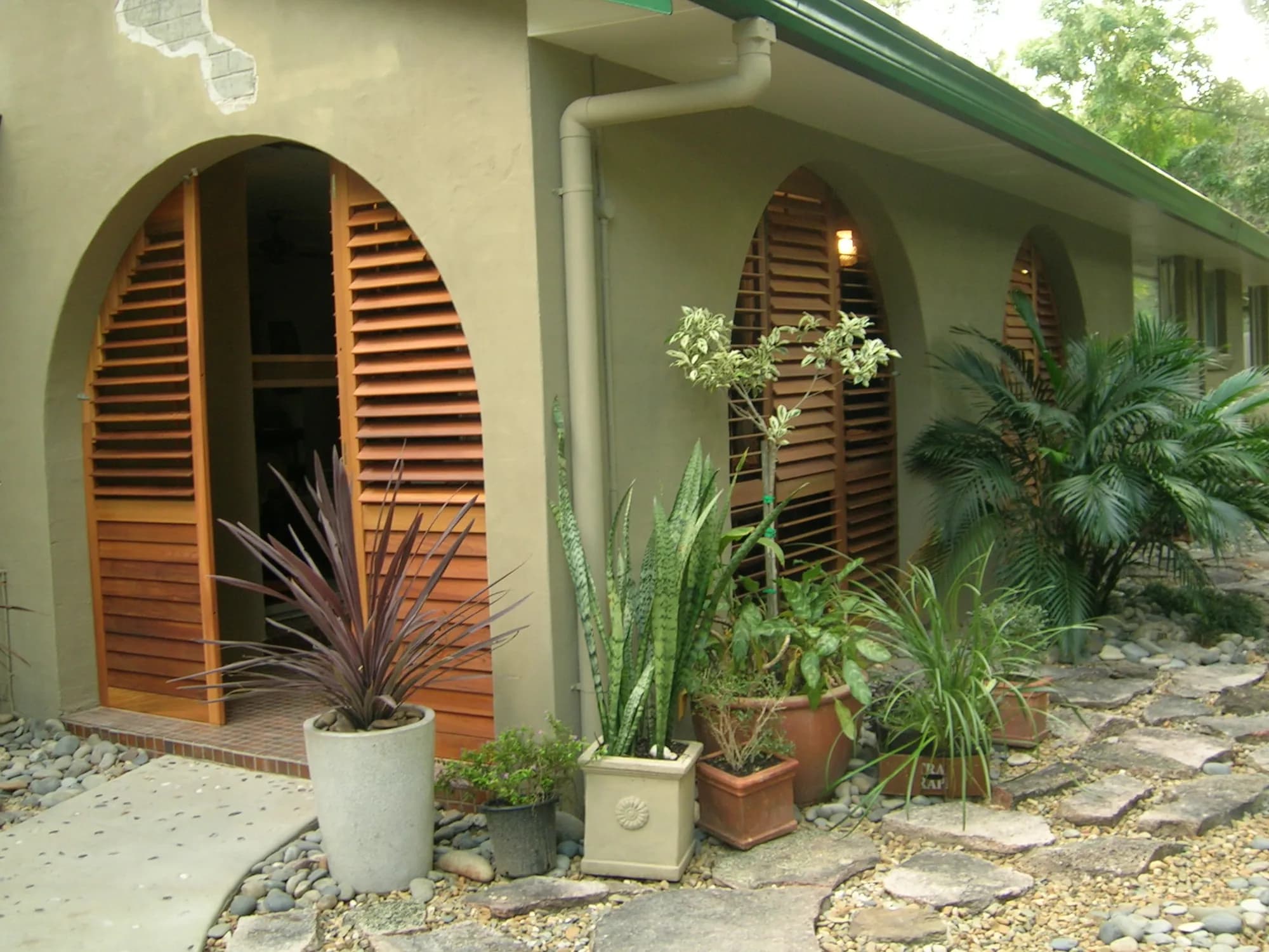 Western Red Cedar shutters made to fit arched windows and an arched doorway — one of our own jobs
