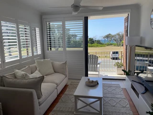 Plantation shutters beside a sliding door left open to the balcony — one of our own jobs